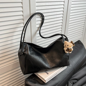 Minimalist black PU leather tote bag with long shoulder straps and plush kitten pendant