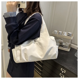 Detailed view of cream nylon shoulder bag with pleated design and side pocket for women