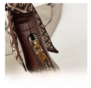 Detailansicht der Retro-Ledertasche mit goldenem Reißverschluss und schickem Seidentuch