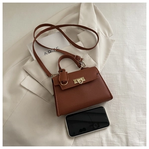 Top view of brown lychee texture handbag with gold twist lock and adjustable strap