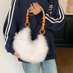 Chic white faux fur crescent shoulder bag with unique orange beaded top handle design