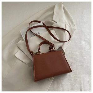 Caramel trapezoid shoulder bag with litchi texture on a chic beige oversized blazer