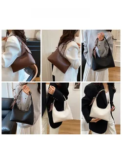 Minimalistische Ledertaschen in drei Farben mit Seidentuch am Griff an einem Model gezeigt