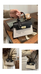 Detail of black pebbled leather and beige canvas handbag with gold metal lock closure