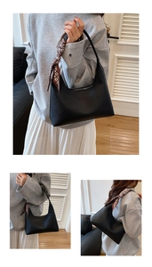 Detail der schwarzen Hobo-Tasche mit Narbenleder und gemustertem Seidenschal-Griff