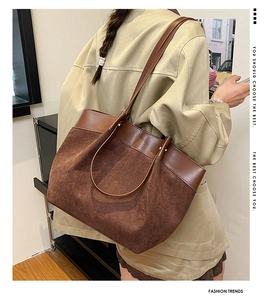 Détail du sac cabas rétro marron foncé en daim et cuir lisse porté par un mannequin
