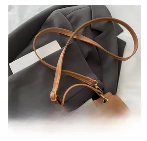 Detail of retro leather crossbody bag with adjustable strap and gold metal turn-lock
