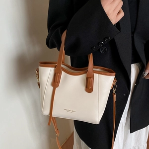 French retro style cream and brown leather bucket bag for women held by model