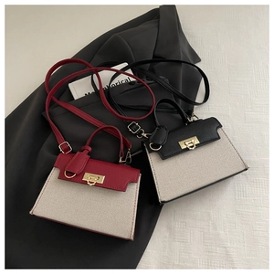 Detail of elegant contrast stitching handbags in red and black with golden hardware clasp