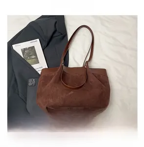 Vue détaillée du sac cabas en daim marron avec finitions en cuir et longues bandoulières