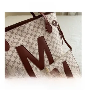 Detail view of cream tote set with all-over M pattern and premium stitched brown leather handles