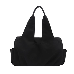Minimalist black nylon tote bag with integrated shoulder straps and side pockets on white back