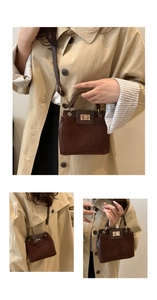 Detail of dark brown leather Kelly bag with gold metal twist lock and suede texture