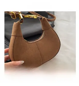 Detailed close-up of brown frosted suede moon bag featuring elegant gold metal hardware