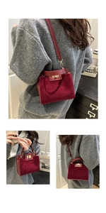 Detail showing burgundy suede leather handbag texture with a golden twist lock closure