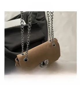 Detail der kamelfarbenen Wildledertasche mit silberner Doppelkette und Strassschloss