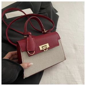 Close-up of contrast crossbody bag featuring red pebble leather and beige canvas textures