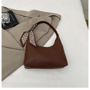 Detail of dark brown litchi pattern hobo bag with elegant black and white silk scarf