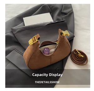 Detail showing internal storage of the brown suede hobo bag with gold hardware
