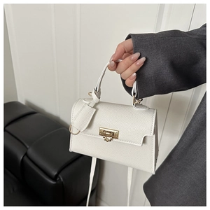 Detail of white lychee leather texture with elegant gold metal buckle on square handbag