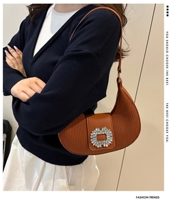 Détail du sac croissant marron plissé avec boucle élégante ornée de strass