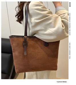 Detail of adjustable metal buckle and suede strap on large brown tote bag