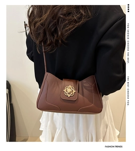 Close-up of brown retro shoulder bag featuring a unique gold flower metal buckle