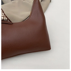 Detail of caramel brown litchi grain leather bag with decorative S-print silk scarf