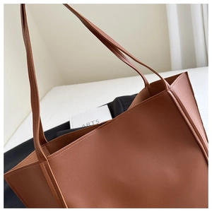 Detailed close-up of a caramel brown faux leather tote bag with soft matte texture