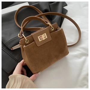 Detail of brown suede tote bag with leather contrast and gold twist-lock closure