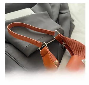 Détail du sac sous le bras plissé marron avec charme de pétale en cristal et boucle