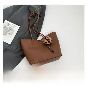 Brown litchi grain leather tote bag with leopard fur ball charm and slim straps