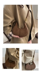 Détail du sac croissant en daim marron foncé avec ferrures dorées et coutures fines
