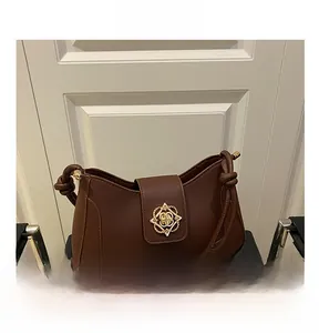 Detail view of the vintage coffee brown shoulder bag with golden metal buckle and knot strap