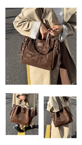 Detail of a brown suede tote bag with Nature & Comfort logo and adjustable shoulder strap