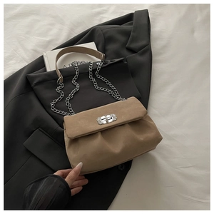 Détail du sac en daim beige avec bandoulière chaîne argentée et boucle en strass