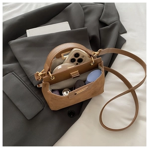 Interior view of brown suede crossbody bag showing phone and lipstick storage