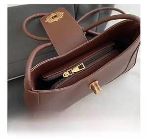 Close-up of golden metal zipper and smooth interior lining on brown leather crossbody bag
