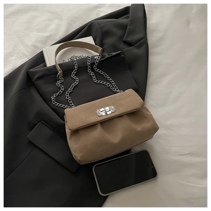 Détail du sac plissé kaki avec bandoulière chaîne argentée et fermoir pivotant en métal