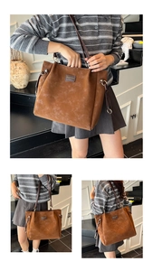 Macro shot of brown vintage tote bag showing matte texture and leather brand logo detail