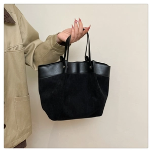 Détail du cabas noir minimaliste avec texture suédée et bordure en cuir brillant