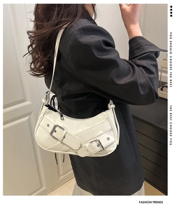 Detail of white crescent hobo bag with adjustable silver buckles and glossy PU texture