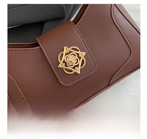 Macro shot of high-quality vintage gold hardware buckle on brown leather crossbody bag