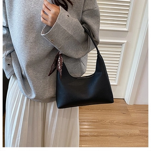 Detail der schwarzen Hobo-Tasche mit Lychee-Maserung und elegantem Seidenschal am Griff
