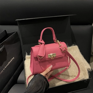 Rose pink litchi grain mini handbag with gold twist lock and adjustable shoulder strap