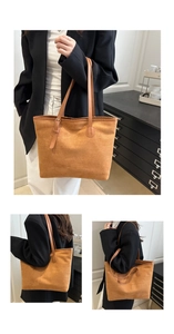 Detail of a large brown suede tote bag with asymmetric leather handles and buckle strap