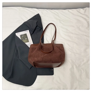 Détail du sac cabas marron foncé montrant le mélange de daim et cuir lisse avec anses