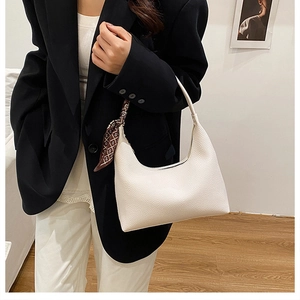 Nahaufnahme der weißen Hobo-Tasche aus Leder mit dekorativem braun gemustertem Seidenschal