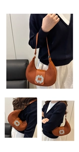 Détail d'un sac Hobo marron avec texture plissée et boucle carrée en cristal