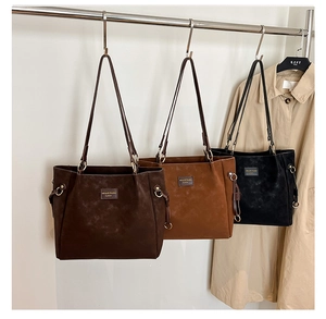 Three minimalist tote bags in black and brown hanging in an autumn fashion studio setting